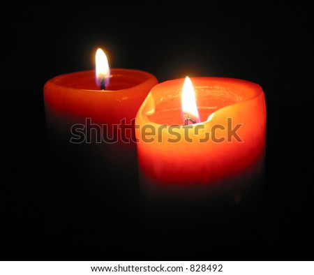 Two red candles burning in the dark