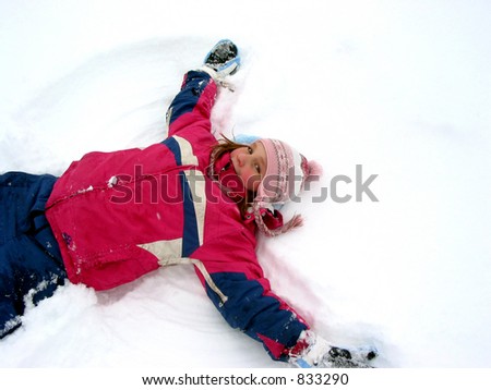 Young girl making a snow angel on fresh white snow