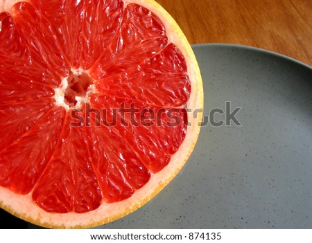 Closeup  of ruby red grapefruit texture on a blue plate
