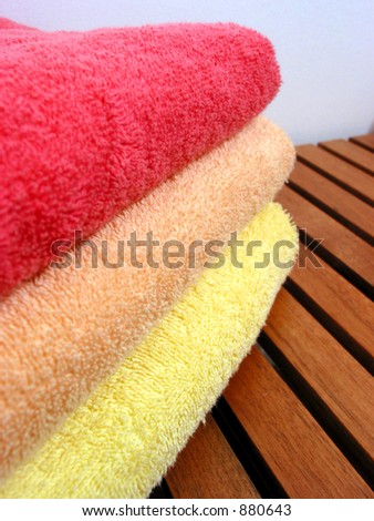 Stack of bright colorful clean towels on a wooden bench