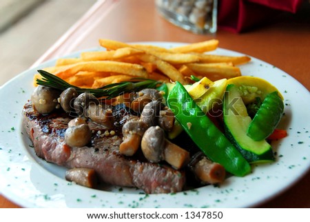 Steak dinner with vegetables and fries