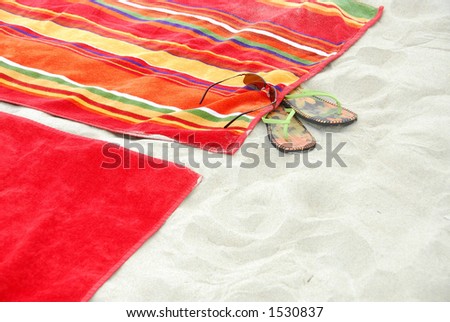 Colorful beach towels on sandy beach