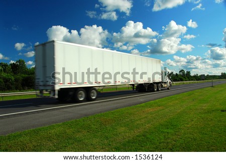 Fast moving eighteen wheeler on a highway, truck is a bit blurred because of speed