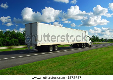 Fast moving truck with white container on highway, blurred because of motion