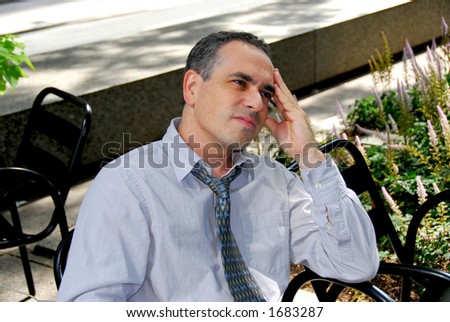 Businessman sitting in outdoor cafe stressed