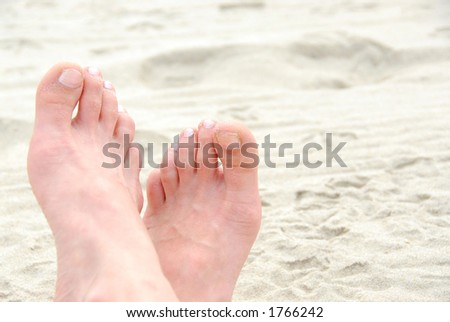 Crossed sandy feet on a beach