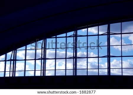 Big window at the moder airport with blue sky and clouds