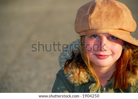 Portrait of a happy smiling girl in winter or fall clothes outside