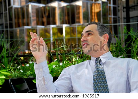 Businessman calling a waiter in outdoor cafe