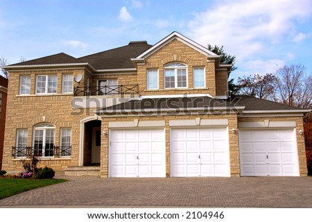 New detached single family luxury home with stone facade and triple garage