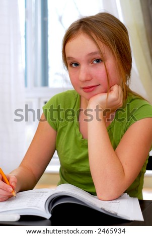 stock photo Young school girl doing homework at her desk