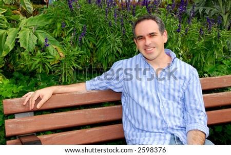 Portrait of an attractive man sitting on a park bench