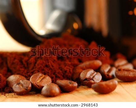 Macro image of coffee beans, ground coffee and black coffee mug