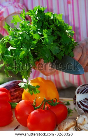 Hands of an elderly woman cooking with fresh vegetables