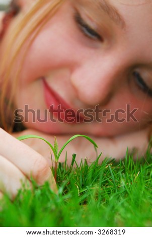 Closeup on a face of a young girl watching a new seedling grow