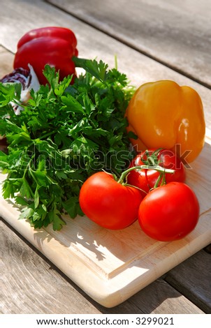 Assorted fresh vegetables on cutting board on rustic table