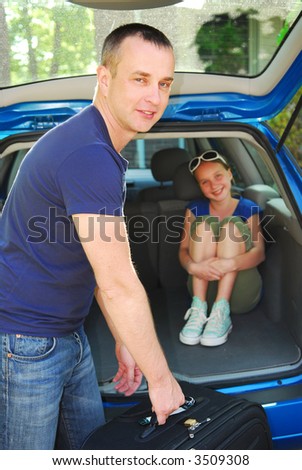Father loading luggage in a car for a family trip