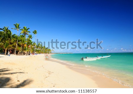 Sandy beach on Caribbean resort and fishing boats at sea