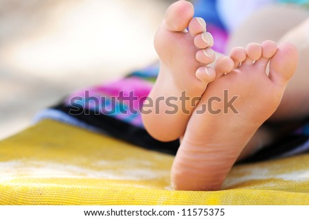 stock photo Closeup of feet of a young girl in chaise lounge relaxing on a