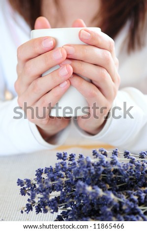 Hands of a woman holding a cup