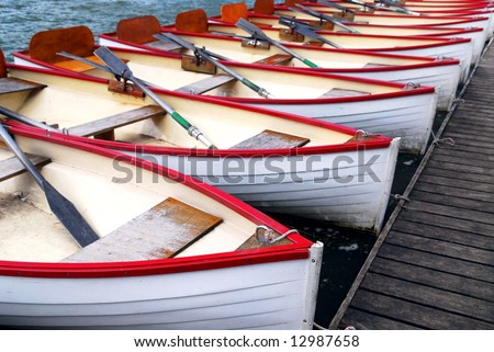 Row of docked wooden rowing boats for rent