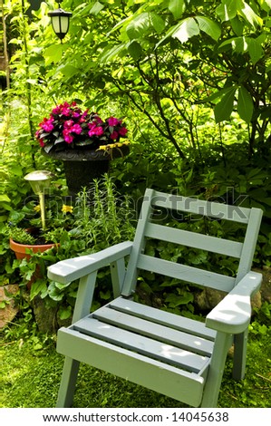 Wooden chair in a secluded corner of lush green garden
