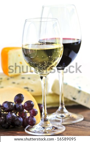 Wineglasses with red and white wine and assorted cheeses