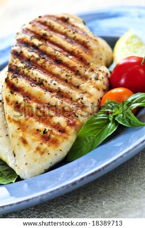 Grilled chicken breasts on a plate with fresh vegetables