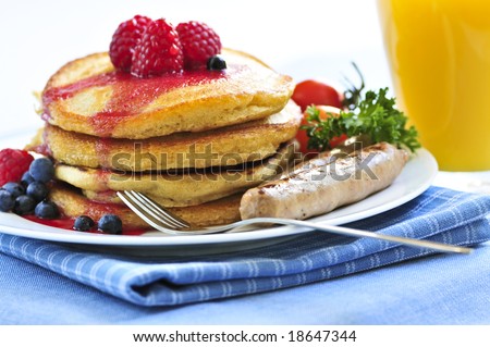 Breakfast of buttermilk pancakes with sausages and fresh berries