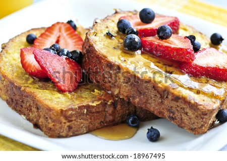 Breakfast of french toast with fresh berries and maple syrup