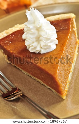 Slice of pumpkin pie with fresh whipped cream