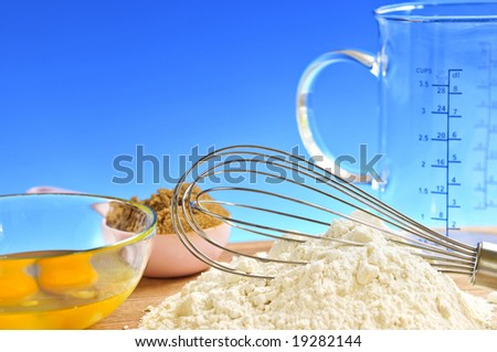 Flour, whisk and eggs in a bowl, baking ingredients