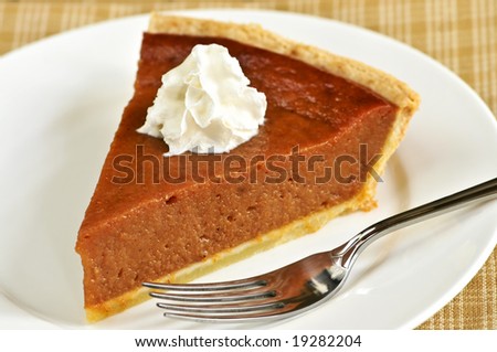 Slice of pumpkin pie with fresh whipped cream