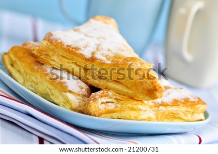 Apple turnovers pastries with coffee cups in the background