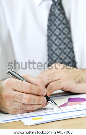 Office worker reviewing generic presentation charts and reports