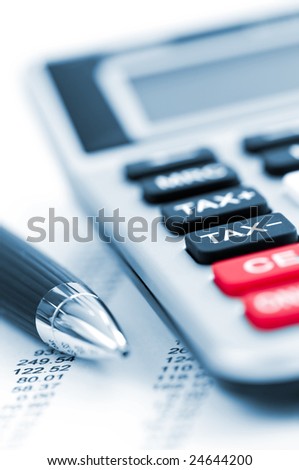 Calculating numbers for income tax return with pen and calculator