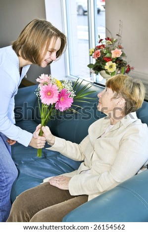 Granddaughter bringing colorful flowers to her grandmother