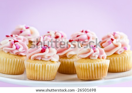 stock-photo-lots-of-tasty-cupcakes-with-icing-on-serving-tray-26501698.jpg