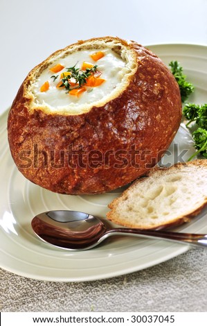 Lunch of soup served in baked round bread bowl