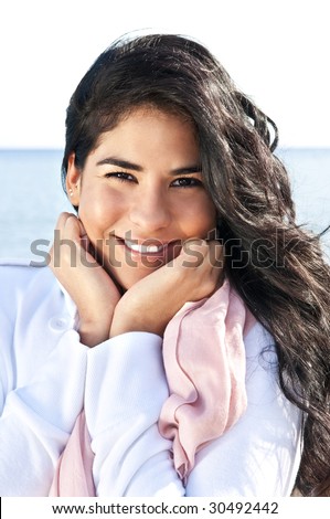 Portrait of beautiful smiling native american girl with hands at her face