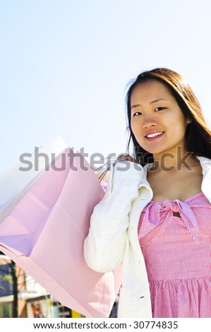 Young korean woman with shopping bags at outdoor mall