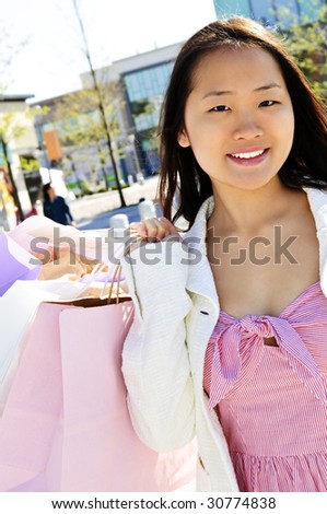Young korean woman with shopping bags at outdoor mall