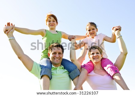 Portrait of happy parents giving children shoulder rides