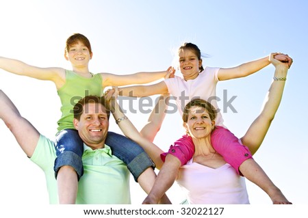 Portrait of happy parents giving children shoulder rides