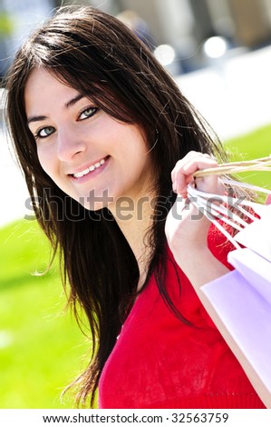 Portrait of young woman with shopping bags at outdoor mall