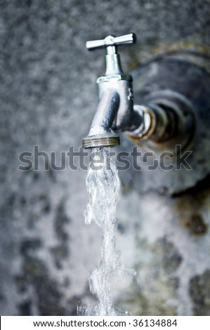Closeup of water running from outdoor wall faucet