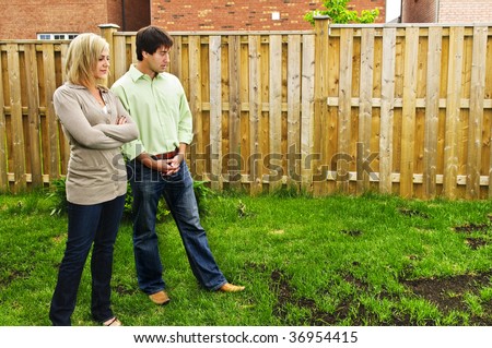 Young couple worried about growing lawn in backyard of new home