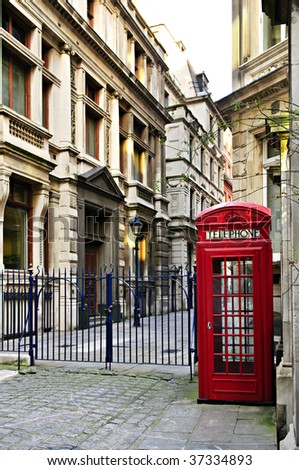 Red telephone box near old buildings in London