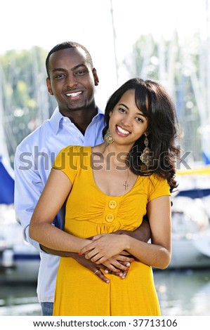 Young romantic couple hugging and standing at harbor
