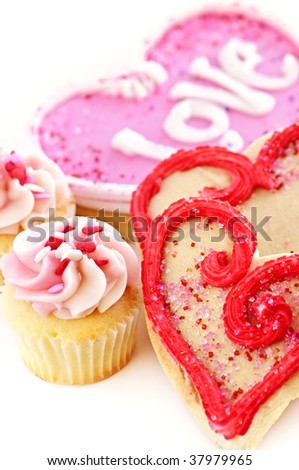 Homemade baked shortbread Valentine cookies and cupcakes with icing on white background